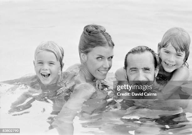 Racing driver Jackie Stewart with his wife Helen and their sons Paul and Mark, in their swimming pool, 16th August 1973.