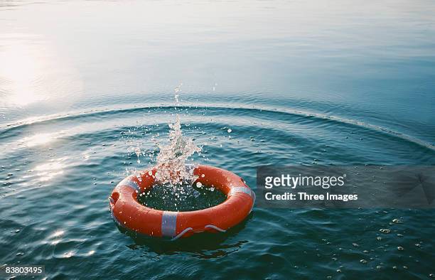 red life-ring with splash  - rettungsring stock-fotos und bilder