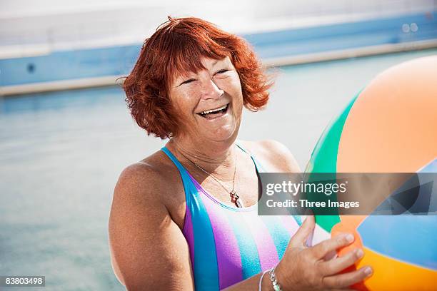 woman laughing holding a beach ball  - rotgefärbtes haar stock-fotos und bilder