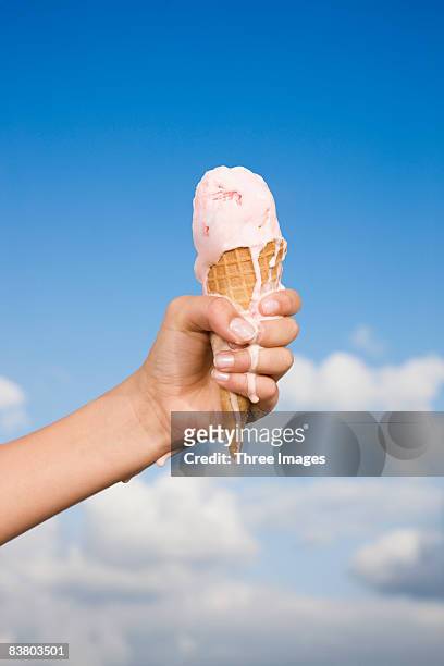 hand holding a melting ice cream  - fundir condição - fotografias e filmes do acervo