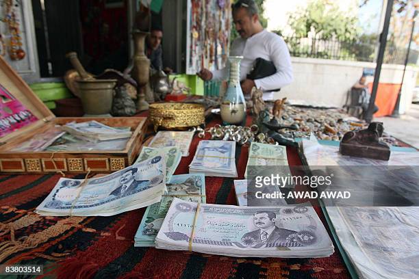 Out-of-circulation Iraqi dinars bearing the portrait of executed Iraqi president Sadam Hussein lie on display at a small shop selling Iraqi...