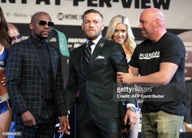 S Dana White grabs Connor Mcgregor's arm as he poses with Floyd Mayweather Jr. During a media press conference August 23, 2017 at the MGM Grand in...