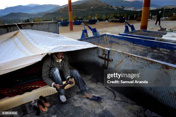 An illigal immigrant sits in his shelter November 20, 2008 in Jaen, Spain. Jobs such as the yearly olive harvest, traditionally undertaken by...