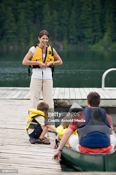 family on dock preparing for canoe ride - life jacket stock pictures, royalty-free photos & images