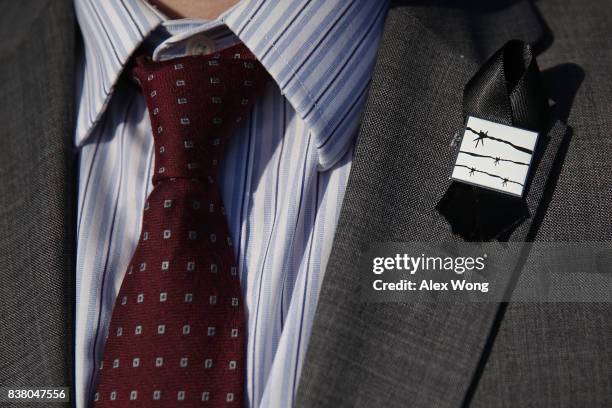 Participant wears a black ribbon on his jacket lapel during a "Black Ribbon Day" remembrance event at the Victims of Communism Memorial August 23,...