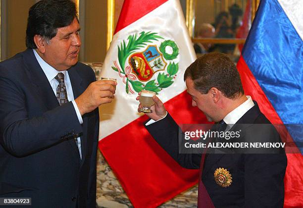 Russian President Dmitry Medvedev and his Peruvian counterpart Alan Garcia toast with a traditional Peruvian "pisco sour" drink, after Medvedev was...