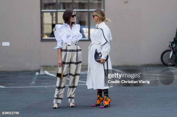 Darja Barannik wearing plaid pants and Janka Polliani wearing Loewe bag, white dress, Balenciaga sock boots outside FWSS on August 23, 2017 in Oslo,...