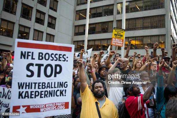 Activists raise their fists as they rally in support of NFL quarterback Colin Kaepernick outside the offices of the National Football League on Park...
