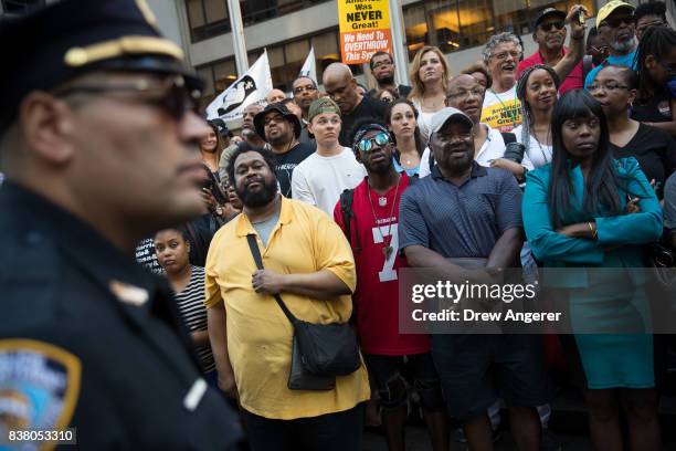 Police officer looks on as activists rally in support of NFL quarterback Colin Kaepernick outside the offices of the National Football League on Park...