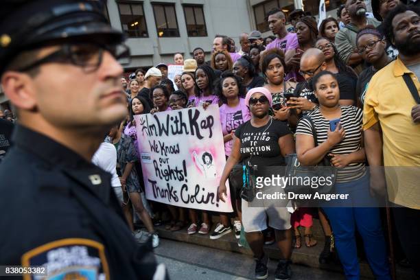 Police officer looks on as activists rally in support of NFL quarterback Colin Kaepernick outside the offices of the National Football League on Park...