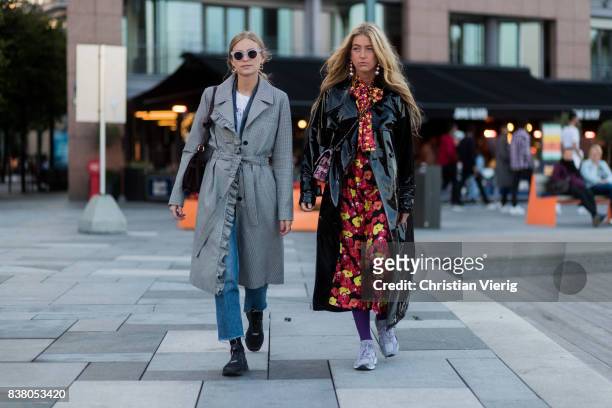 Tine Andrea wearing grey coat, cropped denim jeans and Emili Sindlev wearing dress with floral print, black rain coat outside Mayow on August 23,...