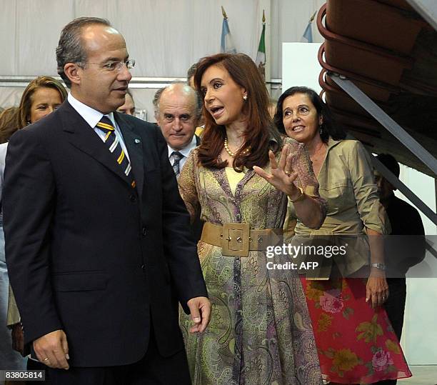 Argentina's President Cristina Kirchner and her Mexican counterpart Felipe Calderon look at part of a mural painting titled "Ejercicio Plastico" by...