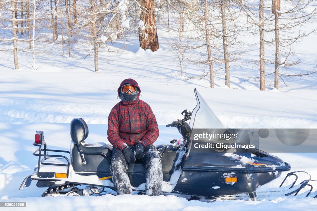 Snowmobile driver resting after ride