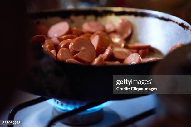 tasty cut sausage in frying pan - cliqueimages stock pictures, royalty-free photos & images