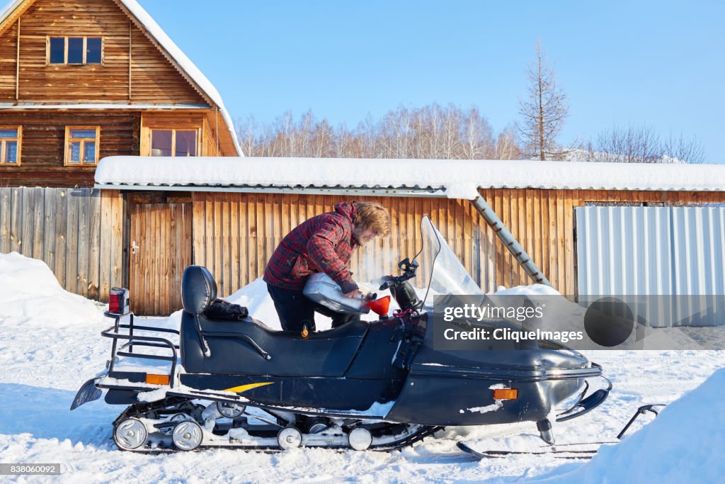 Man preparing for snowmobile ride