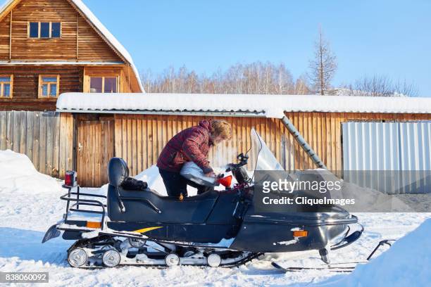 man preparing for snowmobile ride - cliqueimages stock-fotos und bilder