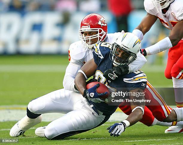 Tight end Antonio Gates of the San Diego Chargers is tackled by linebacker Donnie Edwards of the Kansas City Chiefs in a game at Qualcomm Stadium on...