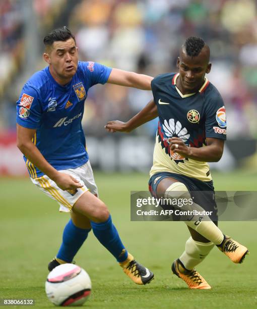 Darwin Quintero of America vies for the ball with Israel Jimenez of Tigres during their Mexican Apertura tournament football match at the Azteca...