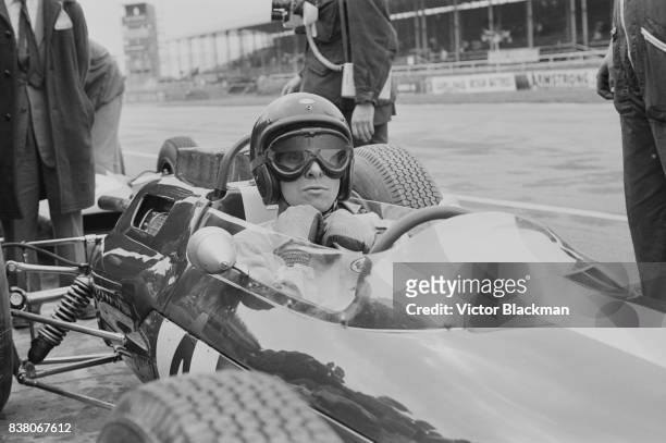 British Formula One racing driver Jim Clark , on the Team Lotus, Lotus 25 Climax V8, makes a pit stop during the British Grand Prix at Silverstone,...