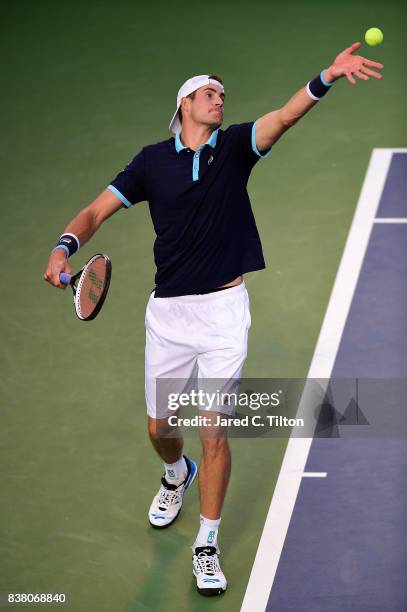 John Isner serves to Borna Coric of Croatia during the fifth day of the Winston-Salem Open at Wake Forest University on August 23, 2017 in...