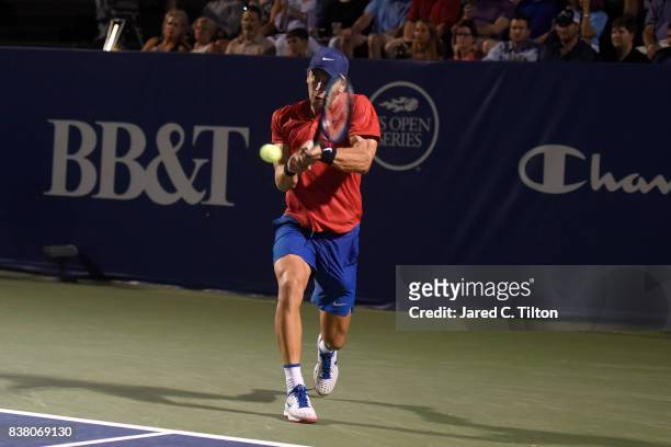 Borna Coric of Croatia returns a shot to John Isner during the fifth day of the Winston-Salem Open at Wake Forest University on August 23, 2017 in...