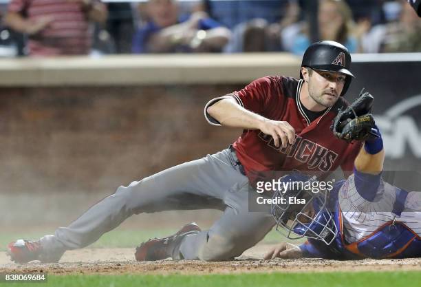 Travis d'Arnaud of the New York Mets holds the ball up to home plate umpire Ryan Additon after he tagged out A.J. Pollock of the Arizona Diamondbacks...