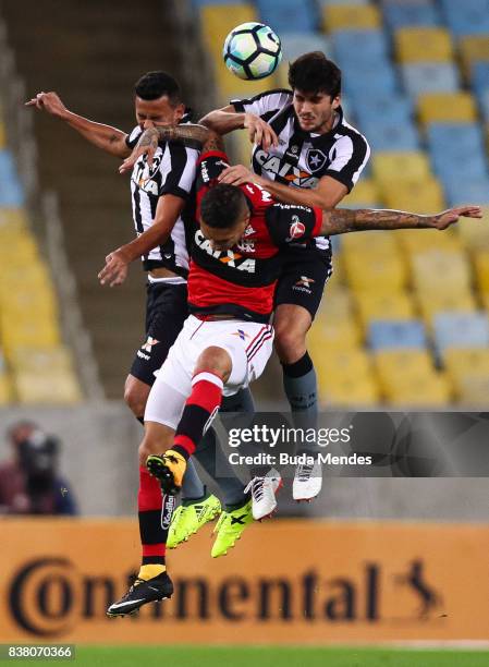 Paolo Guerrero of Flamengo struggles for the ball with Rodrigo Lindoso and Igor Rabello of Botafogo during a match between Flamengo and Botafogo part...