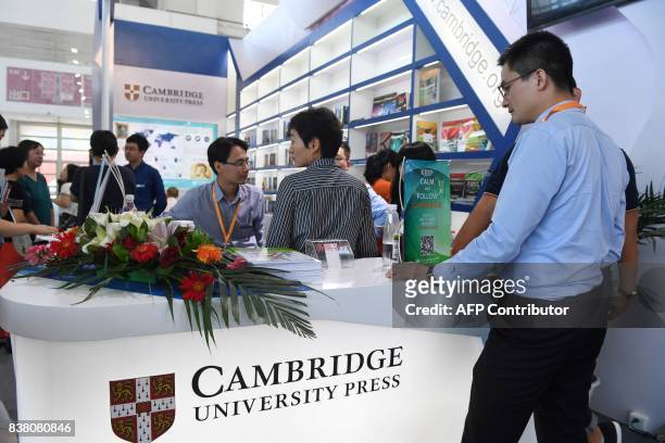 This photo taken on August 23, 2017 shows people at the Cambridge University Press stand at the Beijing International Book Fair in Beijing. Just days...