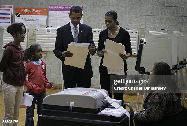 Democratic presidential nominee U.S. Sen. Barack Obama his wife Michelle and daughter Sasha carry their ballots to the vote tabulation machine...