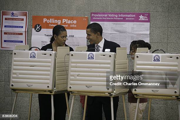 Democratic presidential nominee U.S. Sen. Barack Obama his wife Michelle and daughter Sasha carry their ballots to the vote tabulation machine...