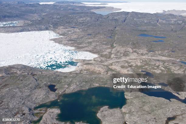 Typical view of the Greenlandic landscape, photographed a couple of hundred meters above the ground. Here we see melt water lakes in the foreground,...