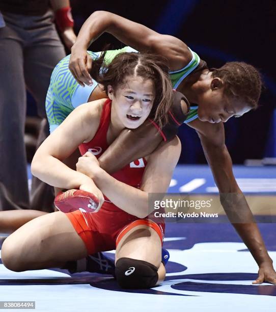 Japan's Haruna Okuno holds the leg of Nigeria's Odunayo Folasade Adekuoroye in the women's 55-kilogram final at the world wrestling championships in...