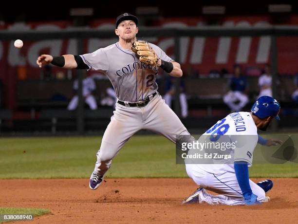 Trevor Story of the Colorado Rockies throws to first past Jorge Bonifacio of the Kansas City Royals as he tries to complete a double play in the...
