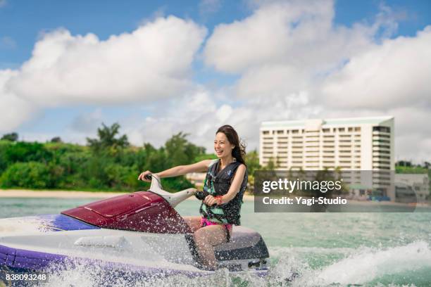 woman enjoying riding a jet ski in guam - jet ski stock pictures, royalty-free photos & images