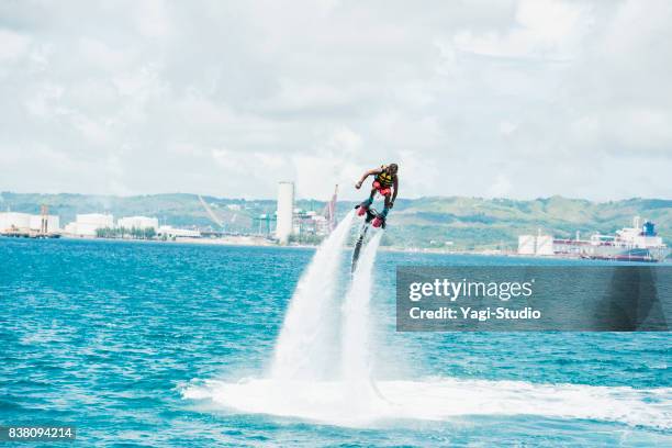 man enjoy flyboarding in guam resort - jet pack stock pictures, royalty-free photos & images