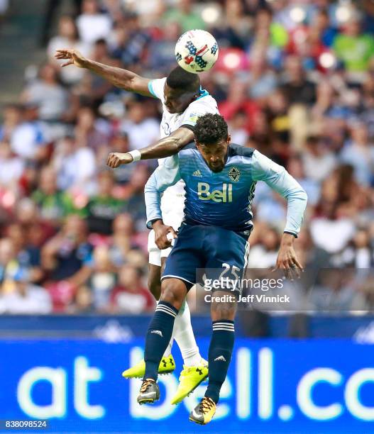 Sheanon Williams of the Vancouver Whitecaps FC collides with Nouhou Tolo of the Seattle Sounders as he heads the ball during their MLS game August...