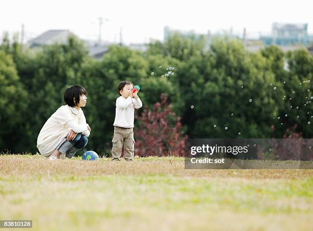 mother and baby boy blowing bubbles in park - kanagawa prefecture stock pictures, royalty-free photos & images