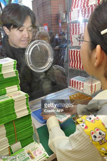 Clerk sells lottery tickets for the 300 million yen Year-end Jumbo Lottery at a Tokyo ticket booth, 25 November 2008. Thousands of punters queued up...