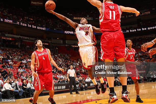 Mario Chalmers of the Miami Heat shoots against Yao Ming of the Houston Rockets on November 24, 2008 at the American Airlines Arena in Miami,...