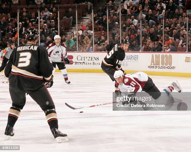 Cody McCormick of the Colorado Avalanche lunges for the puck as Bret Hedican of the Anaheim Ducks defends during the game on November 24, 2008 at...