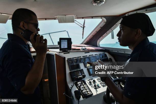 Members of the Malaysian Maritime Enforcement Agency discuss the rescue operation for the missing sailors from the USS John S. McCain off the Johor...