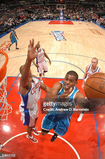 Chris Paul of the New Orleans Hornets avoids contact from Brian Skinner of the Los Angeles Clippers while attempting a shot during their game at...