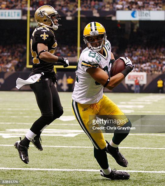 Ruvell Martin of the Green Bay Packers scores a touchdown over Leigh Torrence of the New Orleans Saints on November 24, 2009 at the Superdome in New...