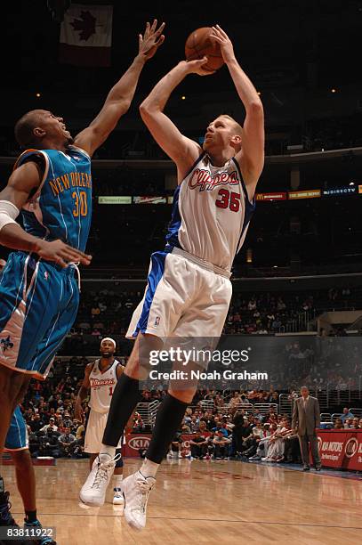 Chris Kaman of the Los Angeles Clippers shoots against David West of the New Orleans Hornets at Staples Center on November 24, 2008 in Los Angeles,...