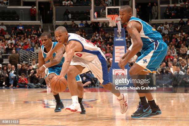 Eric Gordon of the Los Angeles Clippers pursues a loose ball against Chris Paul and David West of the New Orleans Hornets during their game at...