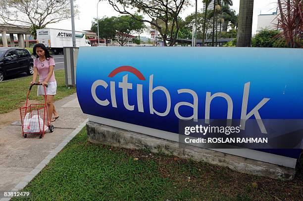 Woman walk past a Citibank sign outside its branch office in Singapore on November 25, 2008. Singapore shares were 3.06 percent higher in early trade...