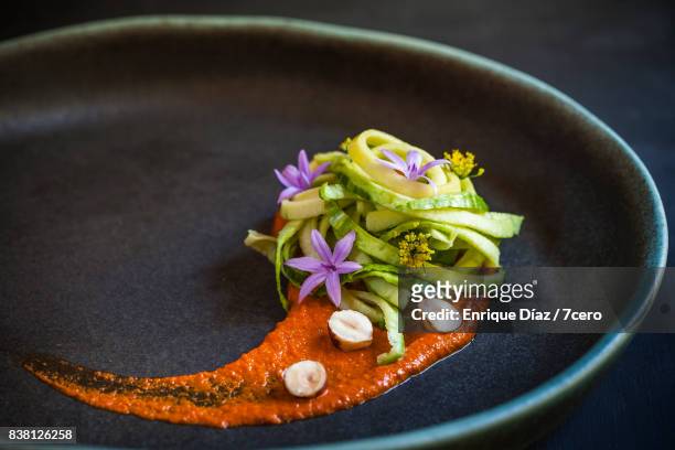 smokey romesco sauce, zoodles and edible flowers - food design stock pictures, royalty-free photos & images