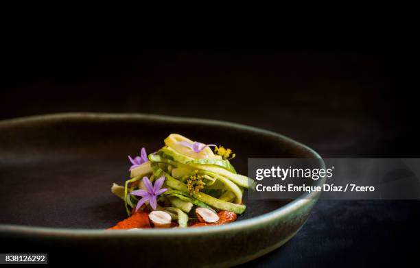 smokey romesco sauce, zoodles and edible flowers side view - stylisme culinaire photos et images de collection