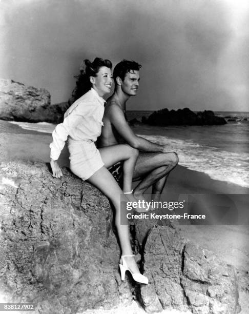 Acteur français Louis Jourdan en compagnie de sa femme Berthe se repose sur la plage de Santa Monica à Los Angeles, Californie, Etats-Unis en 1946.