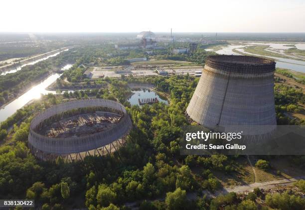 In this aerial view abandoned, partially-completed cooling towers stand at the Chernobyl nuclear power plant as the new, giant enclosure that covers...